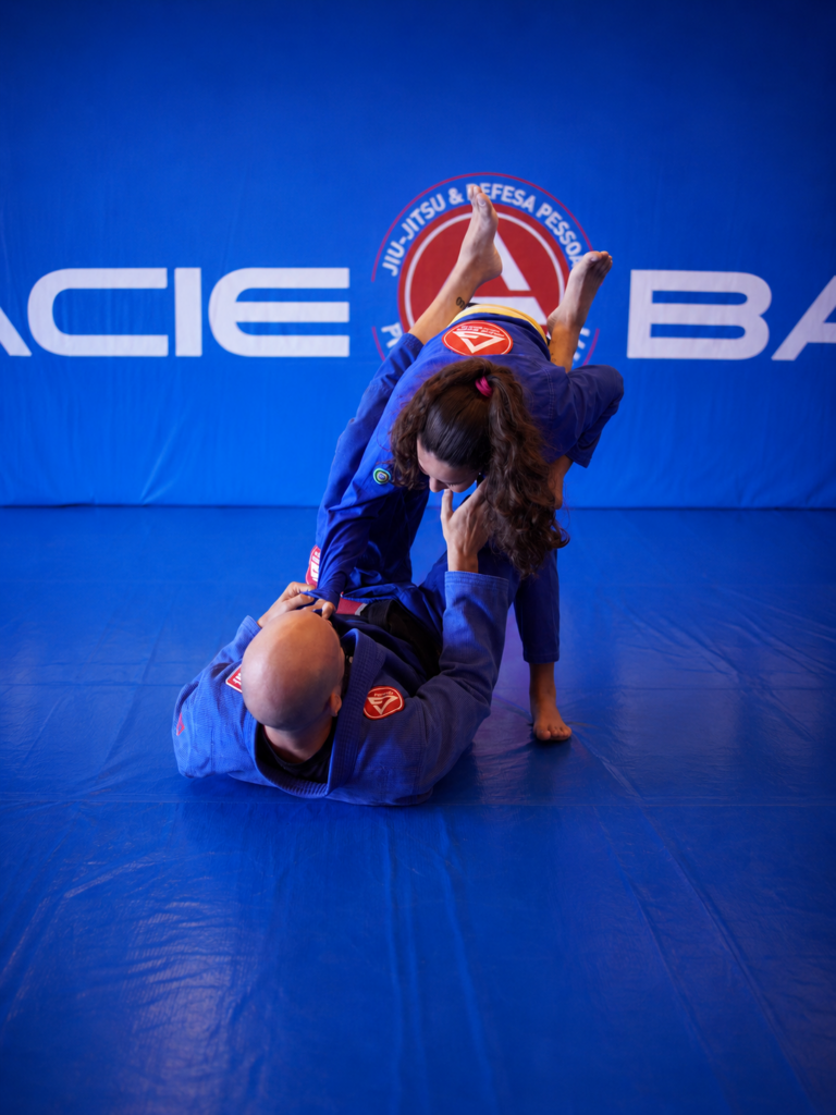 Aluno treinando técnica de jiu-jitsu com o professor